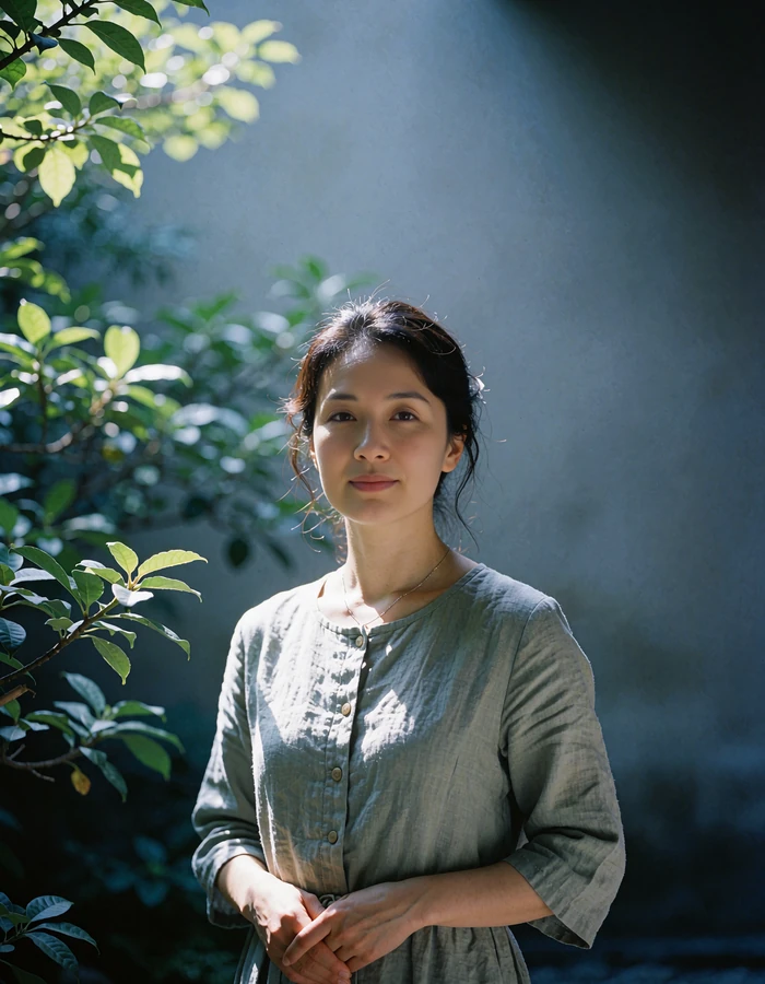 Japanese member in a sage linen dress standing in a quiet temple garden in Kyoto