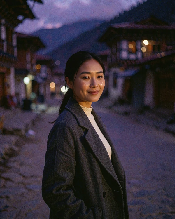 Bhutanese member in a charcoal coat on a quiet mountain-town street at blue hour